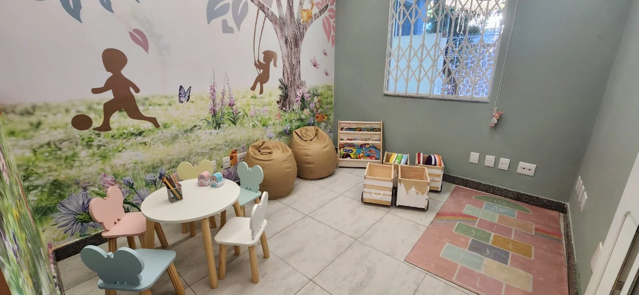 Brinquedoteca lúdica com tapete de amarelinha e livros infantis